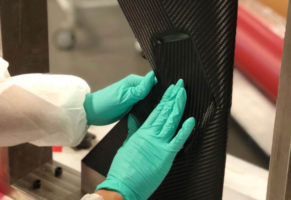 Hydrojet technician hand-finishing a carbon fiber component in the clean room